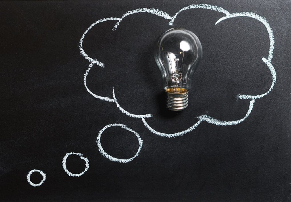 pexels-photo-355952 Light bulb laying on chalkboard with drawn thought bubble, symbolizing creative ideas.